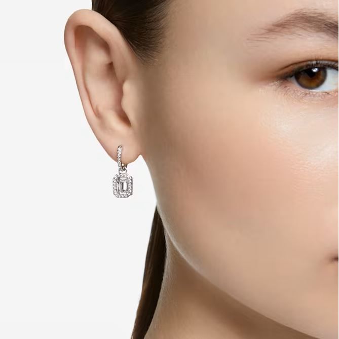 Close-up of a woman wearing SWAROVSKI Mod. 5638495 silver 925° earrings featuring a quartz analog design, water resistant up to 3 ATM.