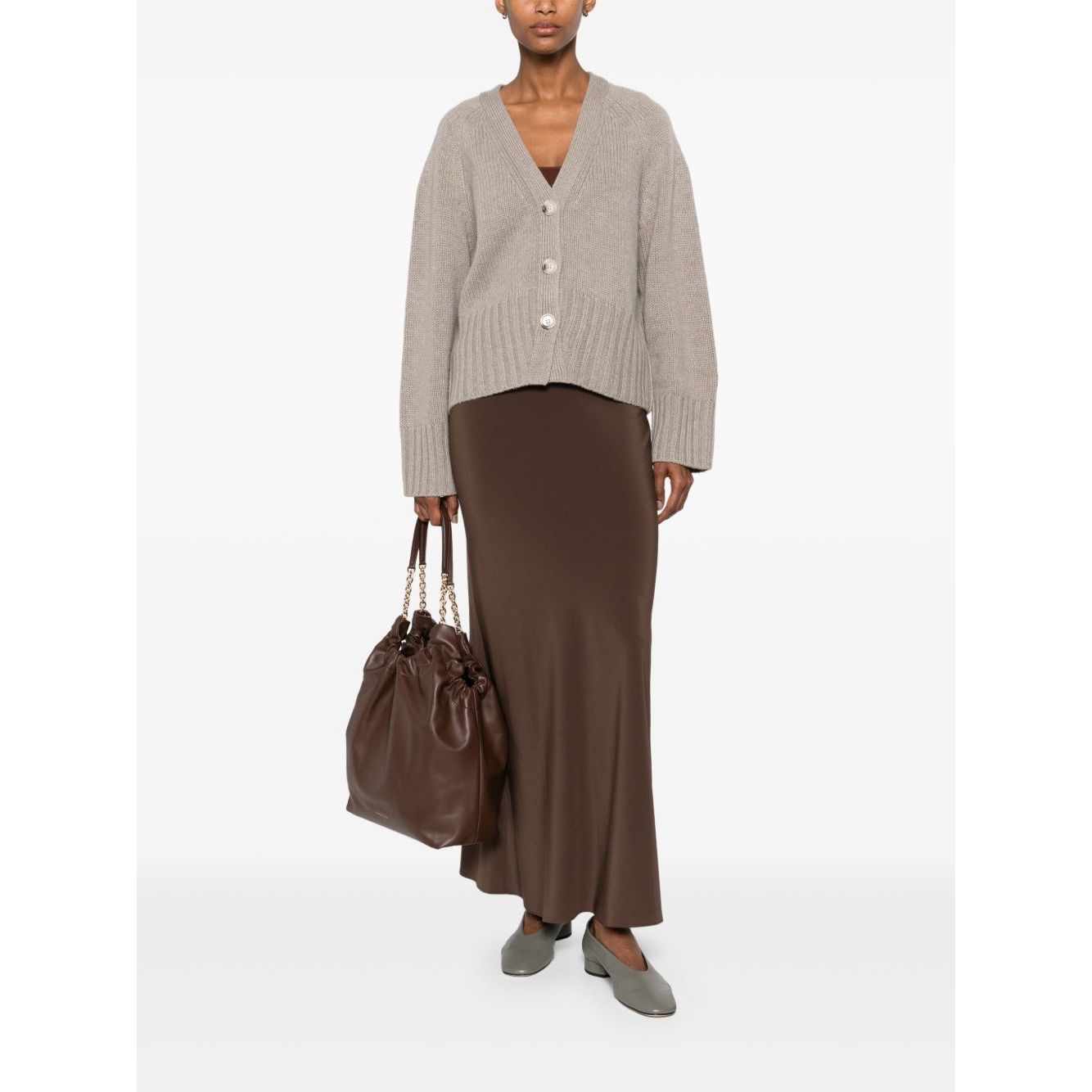 Model wearing SOFT GOAT Sweaters Light Grey cashmere cardigan with V-neck and front button fastening.