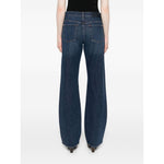 Back view of model wearing navy blue wide-leg Seven Jeans Blue denim with button fly and classic five-pocket design.