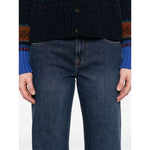 Close-up of Seven Jeans Blue, navy wide-leg denim with button fly, five pockets, belt loops. Model wearing dark sweater.