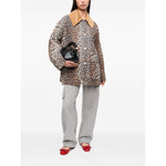 Woman wearing GANNI Jackets Brown with animal print, wide peak lapels, and front button fastening, holding a black bag.