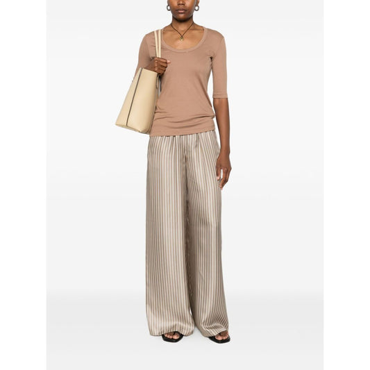 Model wears Fabiana Filippi Sweaters Camel with light brown short sleeves and embellished neckline, paired with striped wide-leg pants.