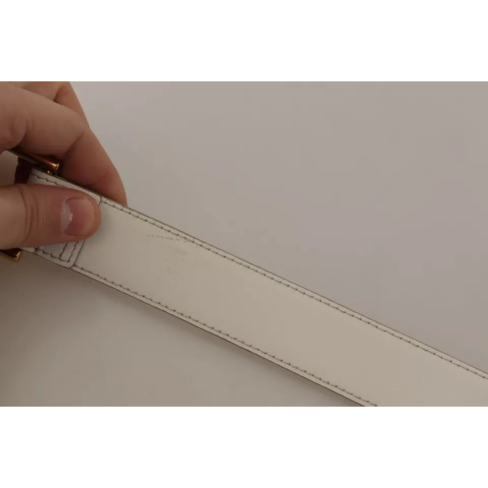 حزام دولتشي آند غابانا المصنوع من الجلد الأبيض والمزين بشعار ذهبي ومشبك معدني