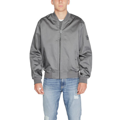 Man wearing Calvin Klein Gray Organic Cotton Bomber jacket standing against white background.