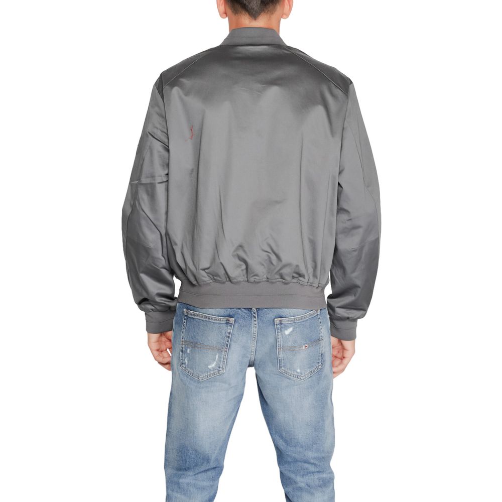 Back view of Calvin Klein Gray Organic Cotton Bomber jacket worn by a model, showcasing its minimalist design in a casual setting.
