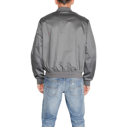 Back view of Calvin Klein Gray Organic Cotton Bomber jacket worn by a model, showcasing its minimalist design in a casual setting.