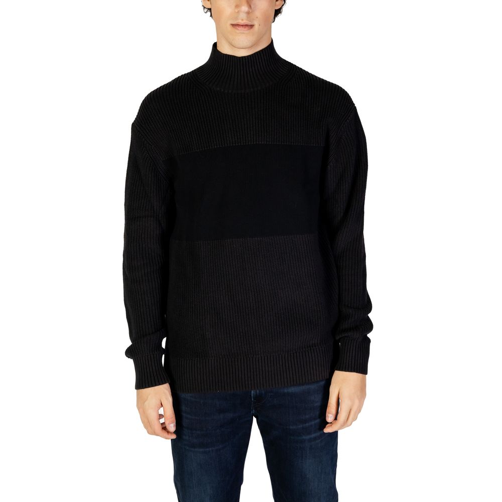 Man wearing Calvin Klein Jeans Black Cotton Sweatshirt with high neckline and ribbed knit design, showcasing elegant contemporary style.
