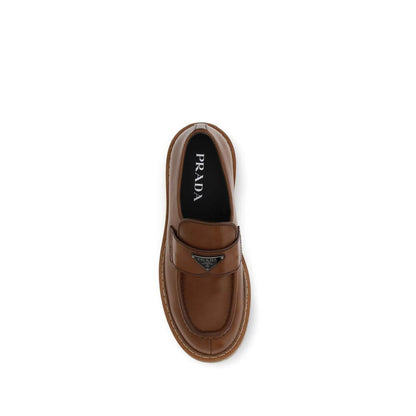 Prada Brown Calf Leather Bos Taurus Slip-On Loafers top view with patent-effect design and iconic triangular glazed plaque.