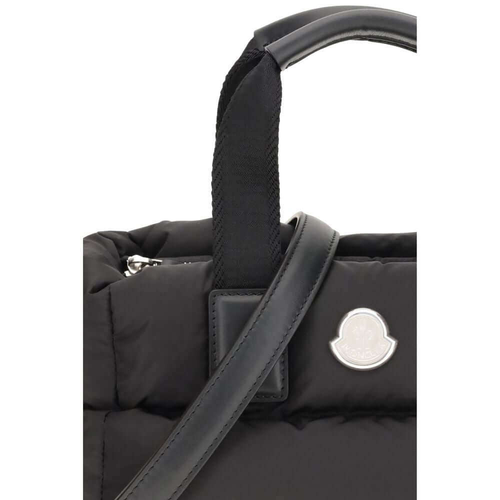 Moncler Black Polyamide Handbag with leather strap and metal logo, close-up view of nylon material and handles.