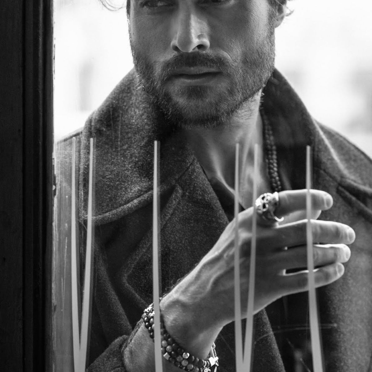 Stylish man wearing AN JEWELS JEWELRY Mod. AA.P255SBK bracelet and rings near window