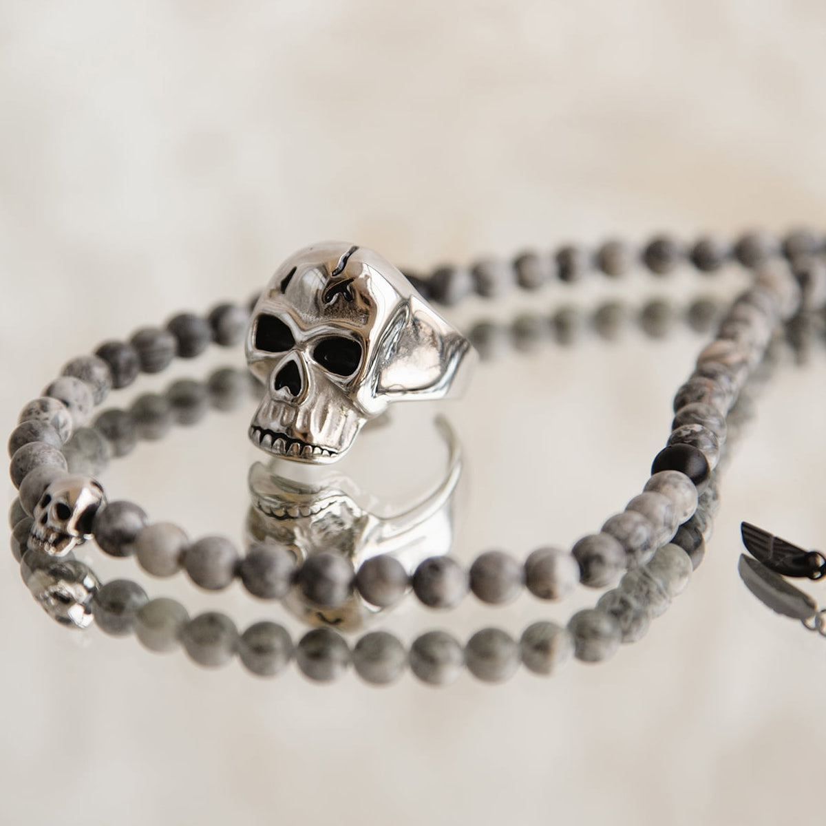 AN JEWELS JEWELRY Mod. AA.R255S-11 featuring skull-themed silver and stone beaded bracelet on a reflective surface