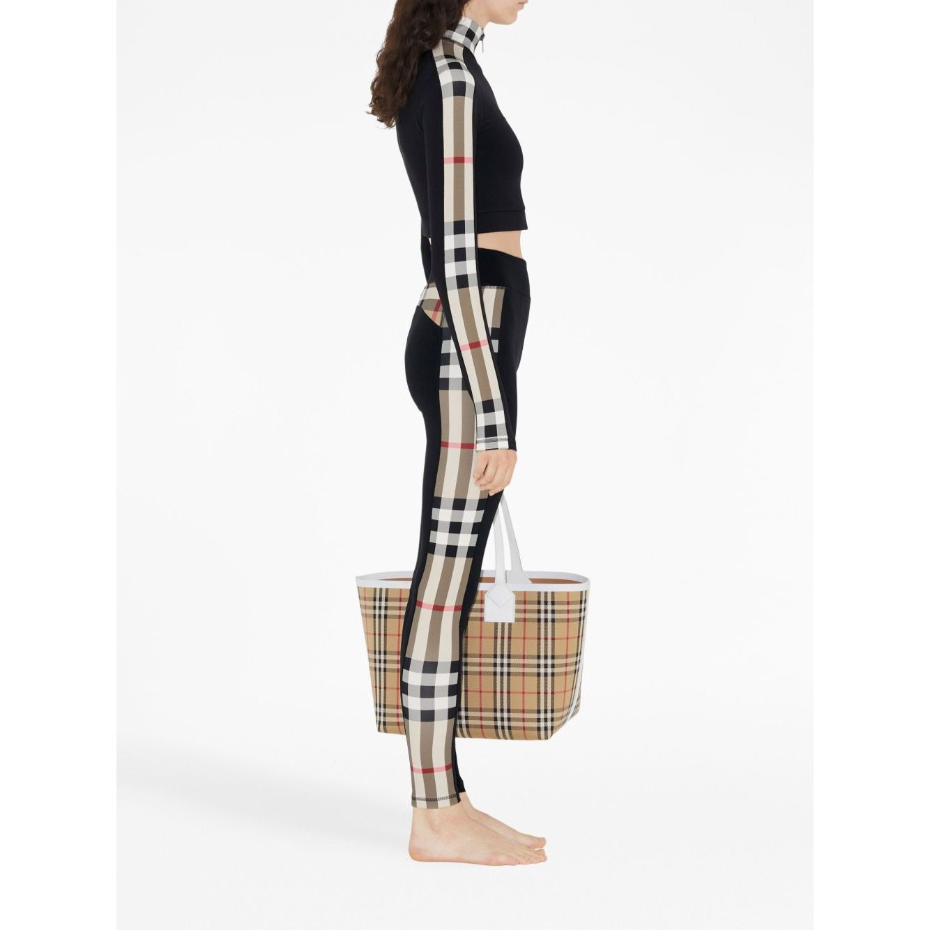 Side view of Burberry Stretch jersey leggings with Check finishes and matching Vintage Check tote bag, featuring check patterns and elastic waistband.