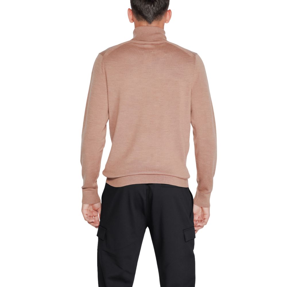 Back view of a model wearing a Calvin Klein Beige Wool Turtleneck sweater, highlighting elegant design and exceptional comfort.