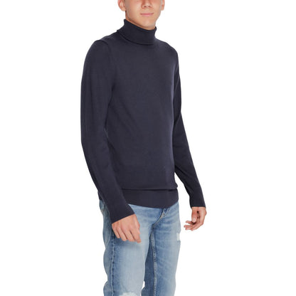 Man wearing Calvin Klein Blue Wool Turtleneck with jeans, showcasing elegant and versatile winter fashion.