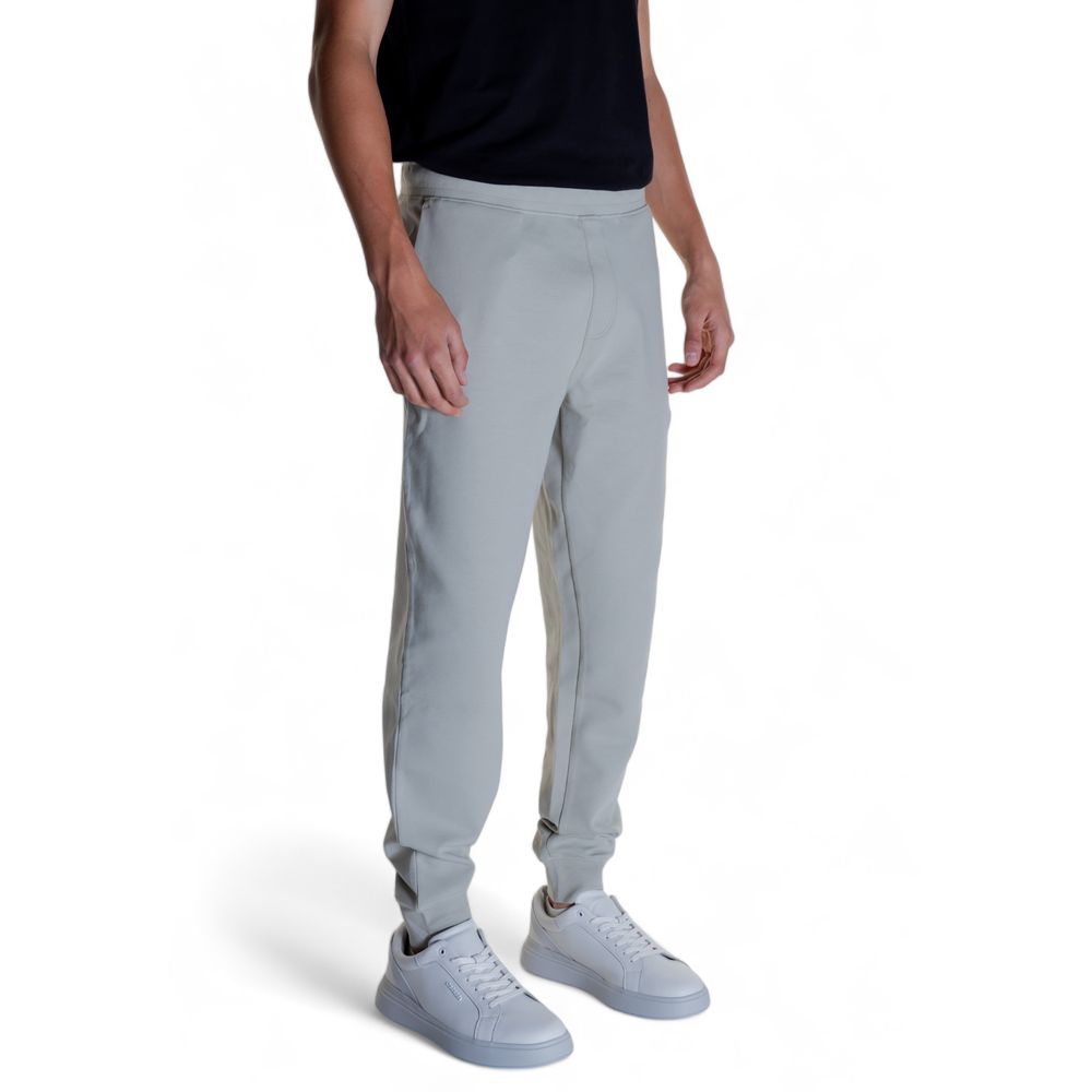 Man wearing Calvin Klein Gray Cotton Joggers (Workout Pants) with white sneakers, showcasing comfortable and modern activewear design.