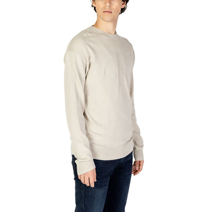 Model wearing Calvin Klein Jeans Beige Organic Cotton Sweatshirt, features CK intarsia logo, casual style with jeans.