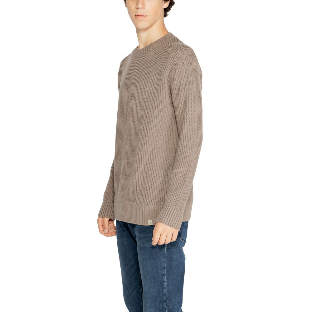 Model wearing Calvin Klein Jeans Brown Organic Cotton Sweatshirt with relaxed fit and vertical ribbed knit, paired with jeans.
