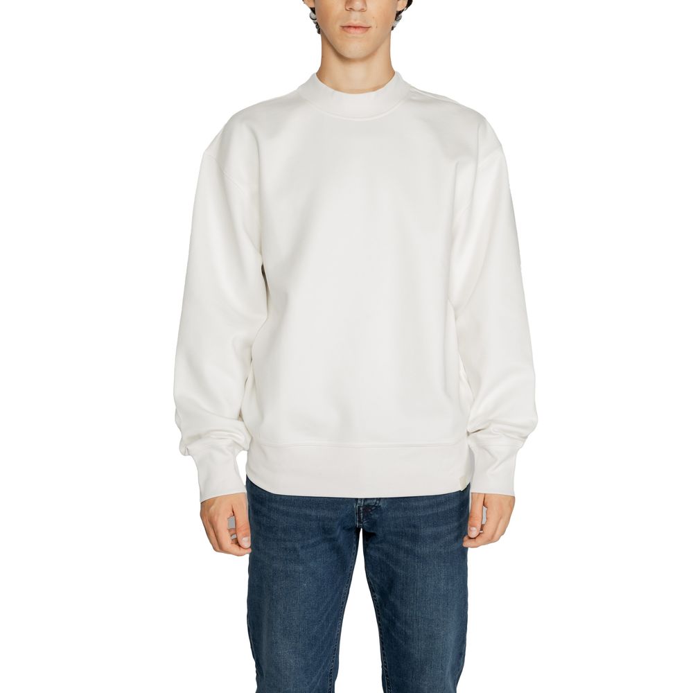 Man wearing Calvin Klein Jeans White Recycled Cotton Sweatshirt with blue jeans, showcasing sustainable fashion.