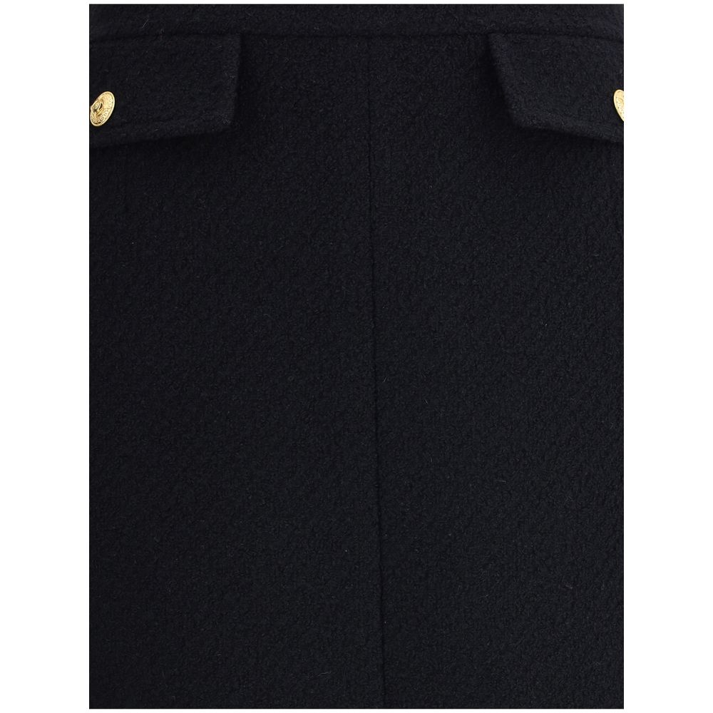 Close-up of Chloé Bouclé wool midi Skirt showing front flap pockets with gold-tone buttons, highlighting the premium fabric texture.
