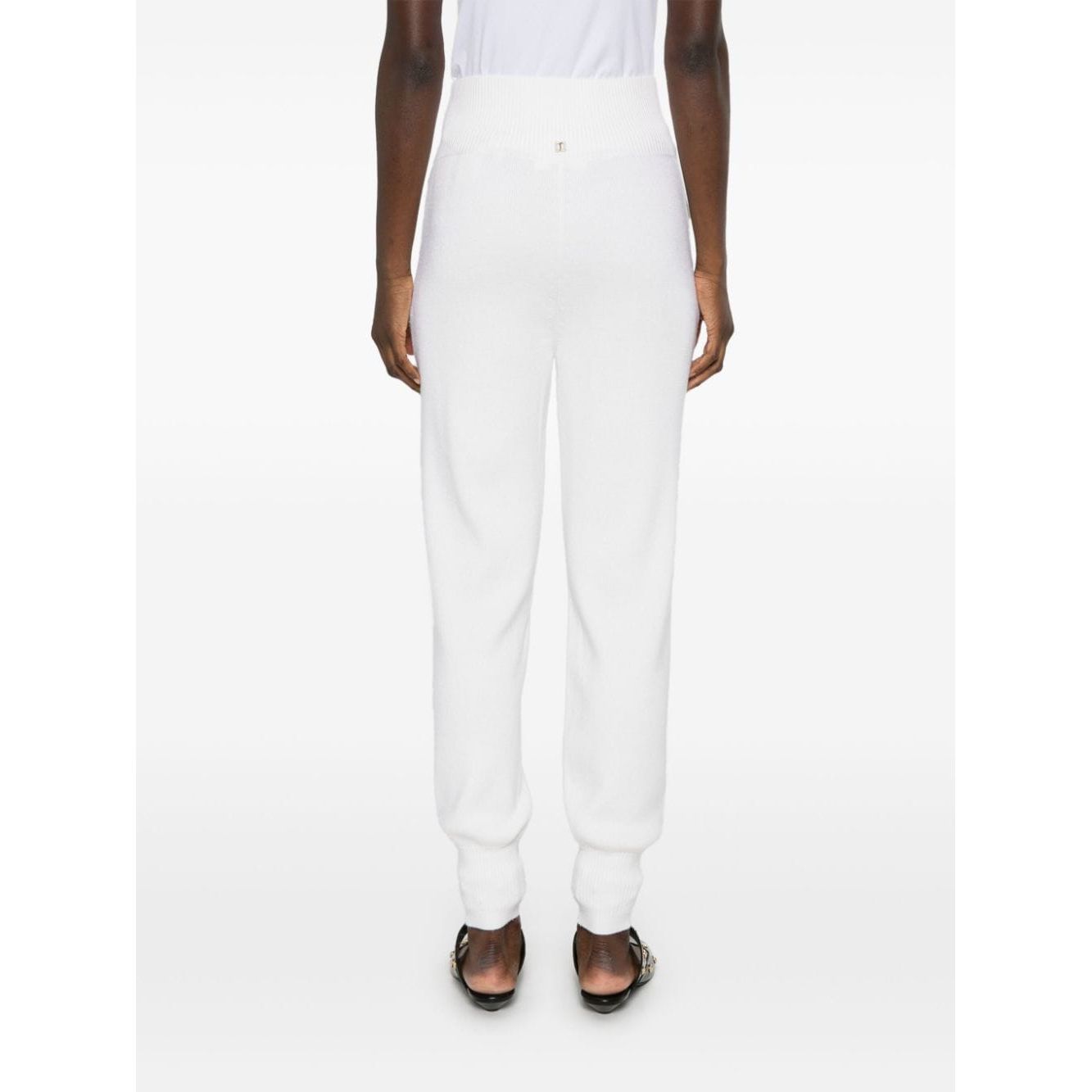 Back view of Chloé Chloè Trousers White, featuring high-waisted ribbed waistband and tapered legs, modeled in cream white knitted wool.