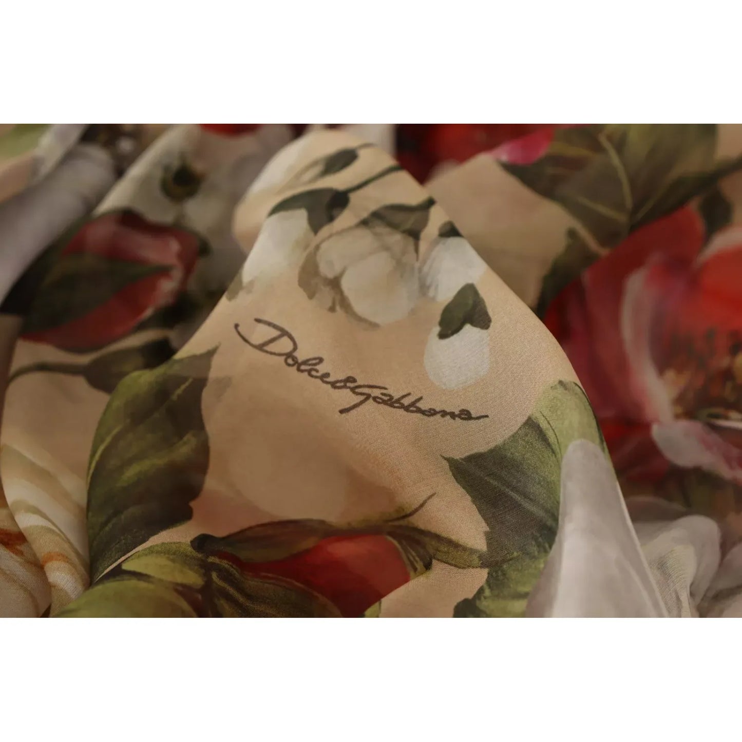 Close-up of Dolce & Gabbana Beige Floral Sleeveless A-line Mini Dress showcasing floral print and logo on silk fabric.
