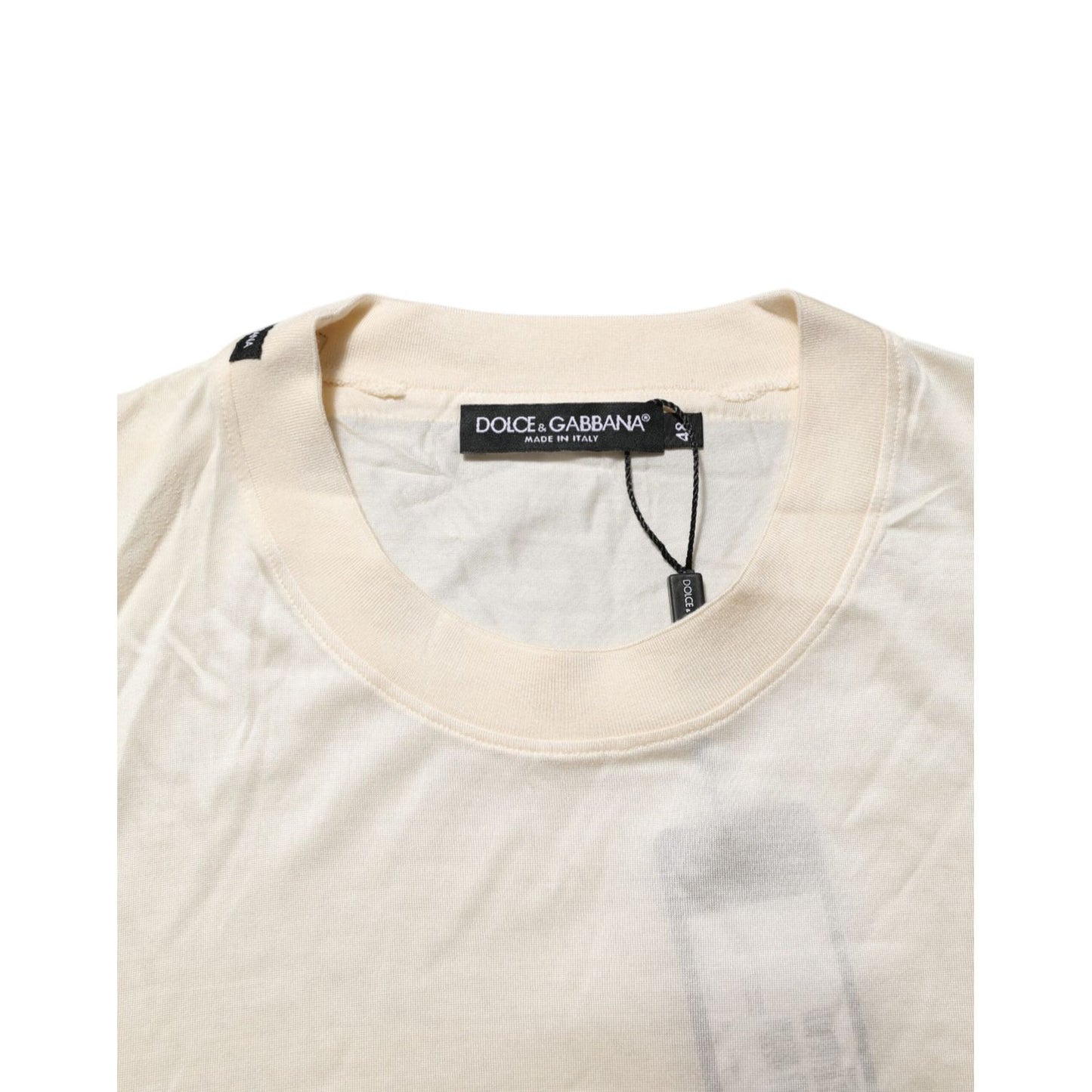 Dolce & Gabbana Off White Silk Crew Neck Short Sleeve T-shirt close-up view showing label and neckline details.