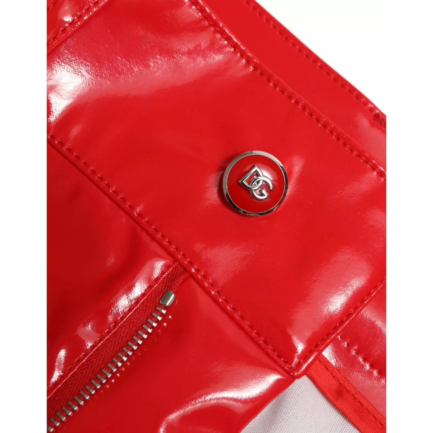 Close-up of Dolce & Gabbana Red High Waist Skinny Trouser Shiny Pants with logo detail and zipper, highlighting fabric texture and design.