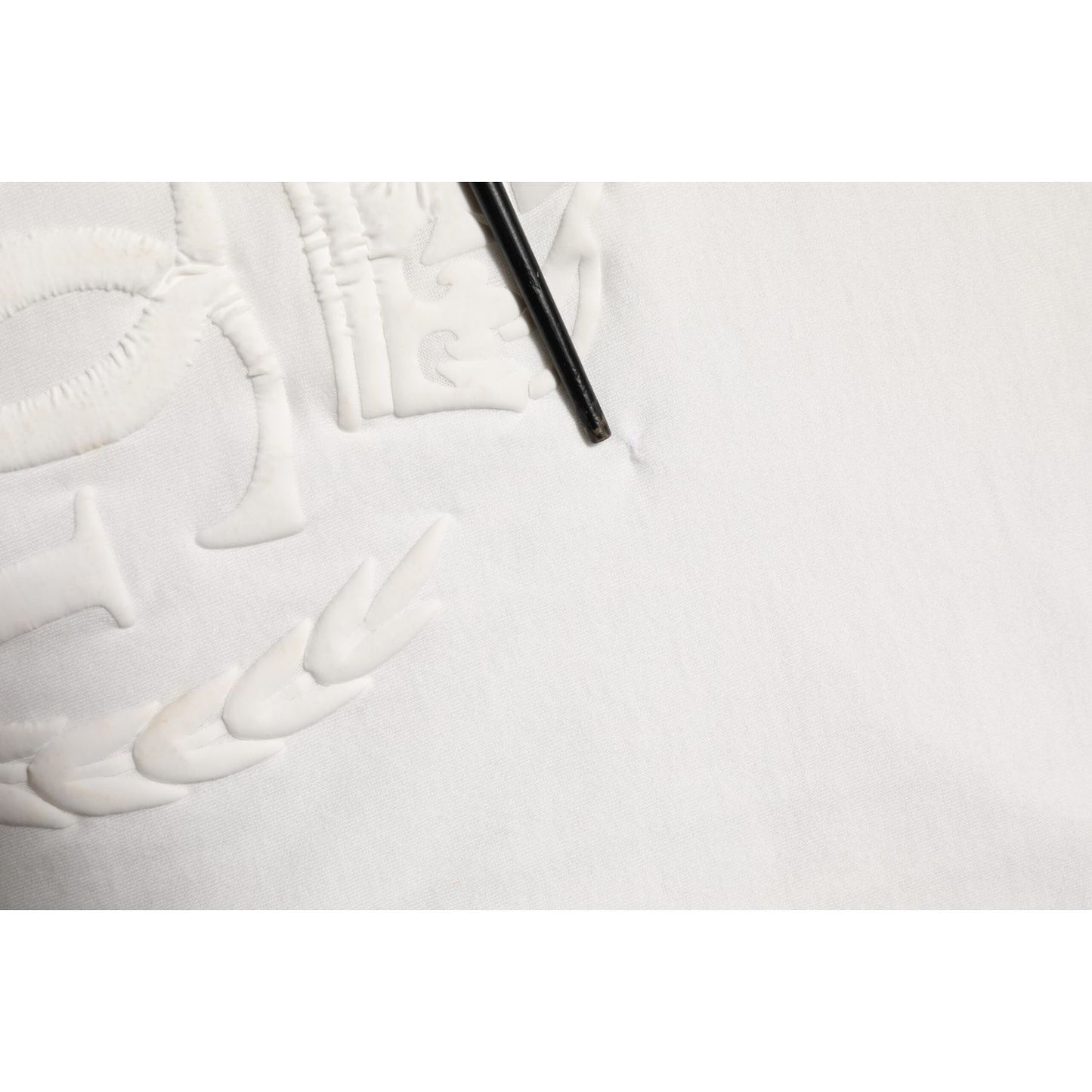 Close-up of Dolce & Gabbana White Cotton DG Crown Embossed Men T-shirt showing fixed hole in fabric