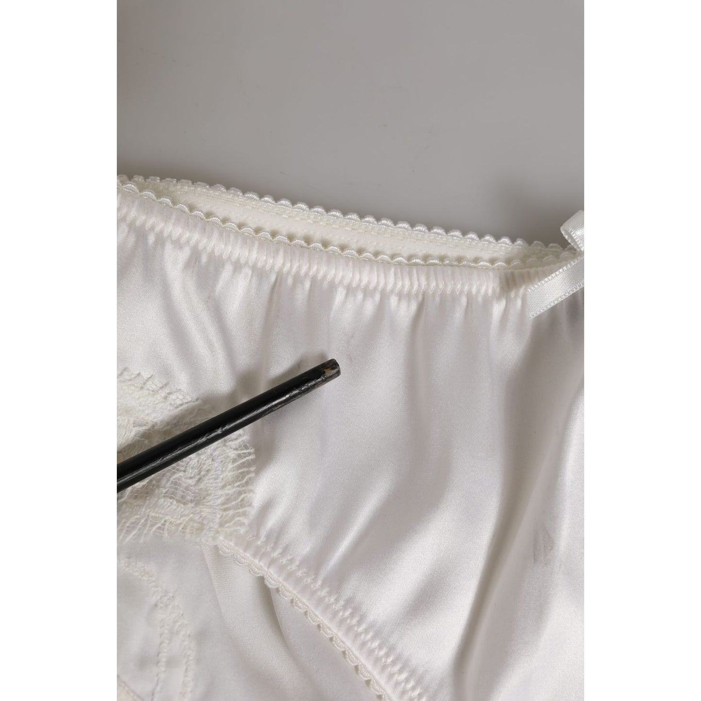 Close-up of Dolce & Gabbana White Silk Satin Floral Lace Panty Brief Underwear showing delicate lace trim and minor fabric stain.