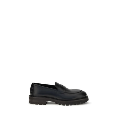 Ferragamo Black Rubber Slip-On Loafers with brushed calfskin upper and bold lug tread sole, showcasing elegance and modern style.