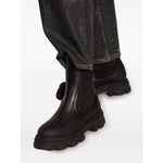 Alt Tag: Person wearing GANNI Boots Black with chunky rubber sole and elasticated side panels, showcasing slip-on style and Chelsea design.