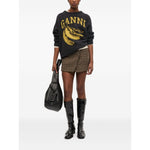Model wearing GANNI Sweaters Grey crew neck with banana print, long sleeves, ribbed cuffs and hem, styled with plaid shorts and boots.