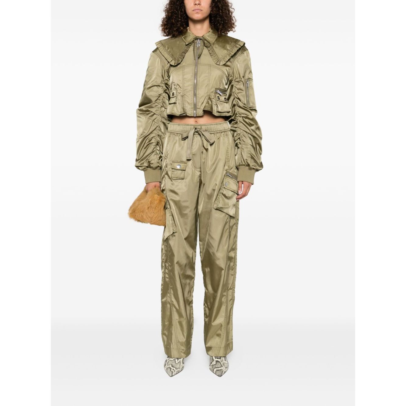 Model wearing GANNI Trousers Green with elasticated waistband and cargo pockets.