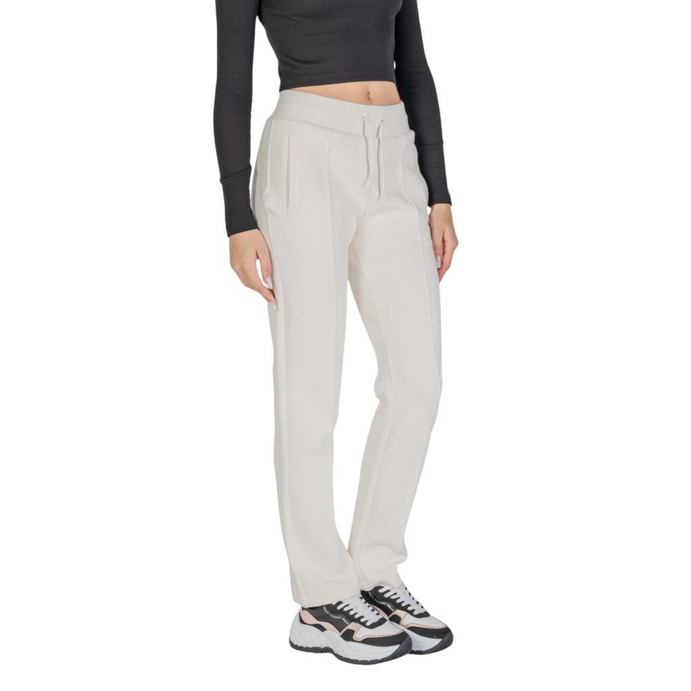 Woman wearing Guess Active Cream Cotton Joggers (Workout Pants) for gym or casual outings, straight leg design, comfortable fit, versatile style.