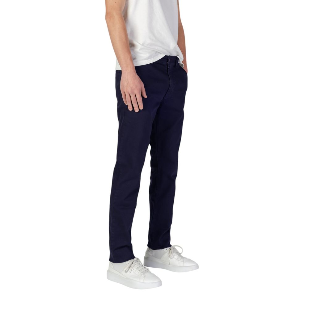 Man wearing Hugo Boss Blue Cotton Skinny Pants showcasing slim fit design with casual sneakers and white shirt.