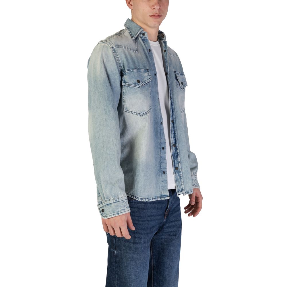 Hugo Boss Light Blue Denim Shirt with snap-button closure, 100% cotton, featuring chest pockets and contrast stitching. Model wearing casual style.
