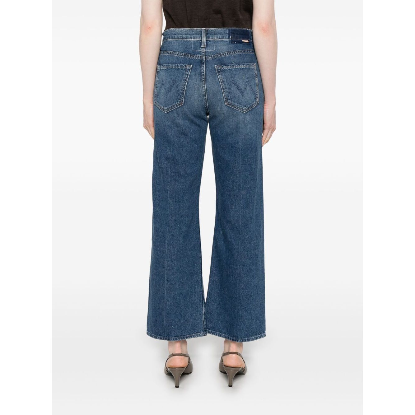 Back view of model wearing Mother Jeans Blue with classic five pockets and whiskering effect, highlighting the indigo denim and ankle length.