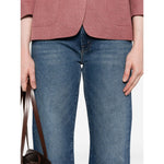 Model wearing Mother Jeans Blue featuring indigo denim, front button, zip fastening, and classic five pockets.
