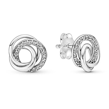 Elegant silver knotted design earrings with sparkling stones on white background, showcasing intricate craftsmanship and style.
