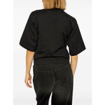 Back view of model wearing Palm Angels crop T-shirt with logo, black crew neck, drop shoulder, short sleeves, straight hem, shown in size S.