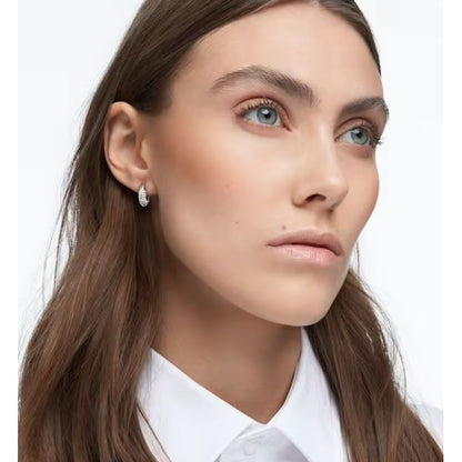 Woman wearing SWAROVSKI Mod. 5618306 earrings made of Silver 925°, featuring a quartz analog movement, in official packaging.