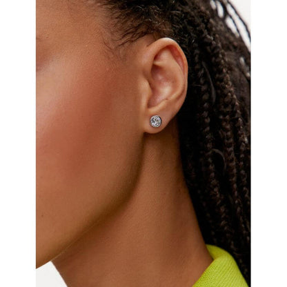 Close-up of SWAROVSKI Mod. 5696073 silver 925° earrings worn by a woman, showcasing quartz analog design, 38 mm case, official packaging.