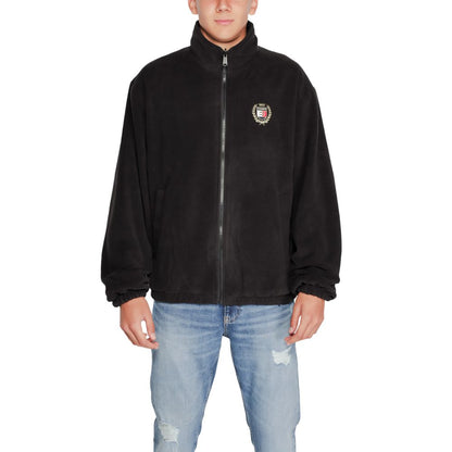 Man wearing Tommy Hilfiger Jeans Black Recycled Polyester Shell Jacket with high collar and embroidered crest.