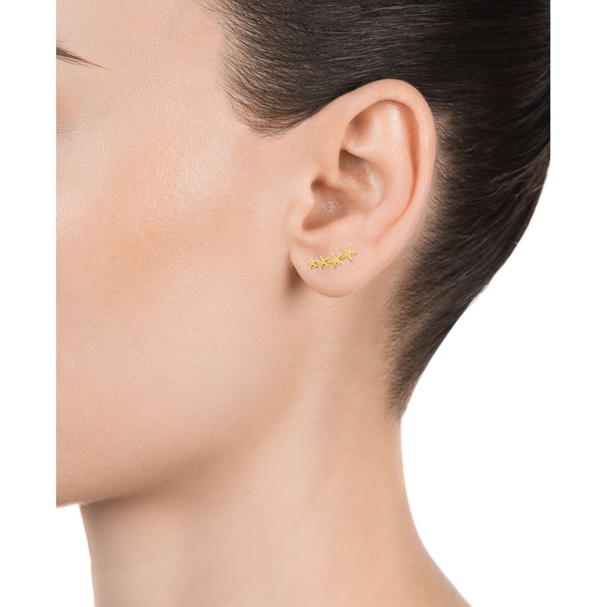 Close-up of woman wearing gold star earrings on ear