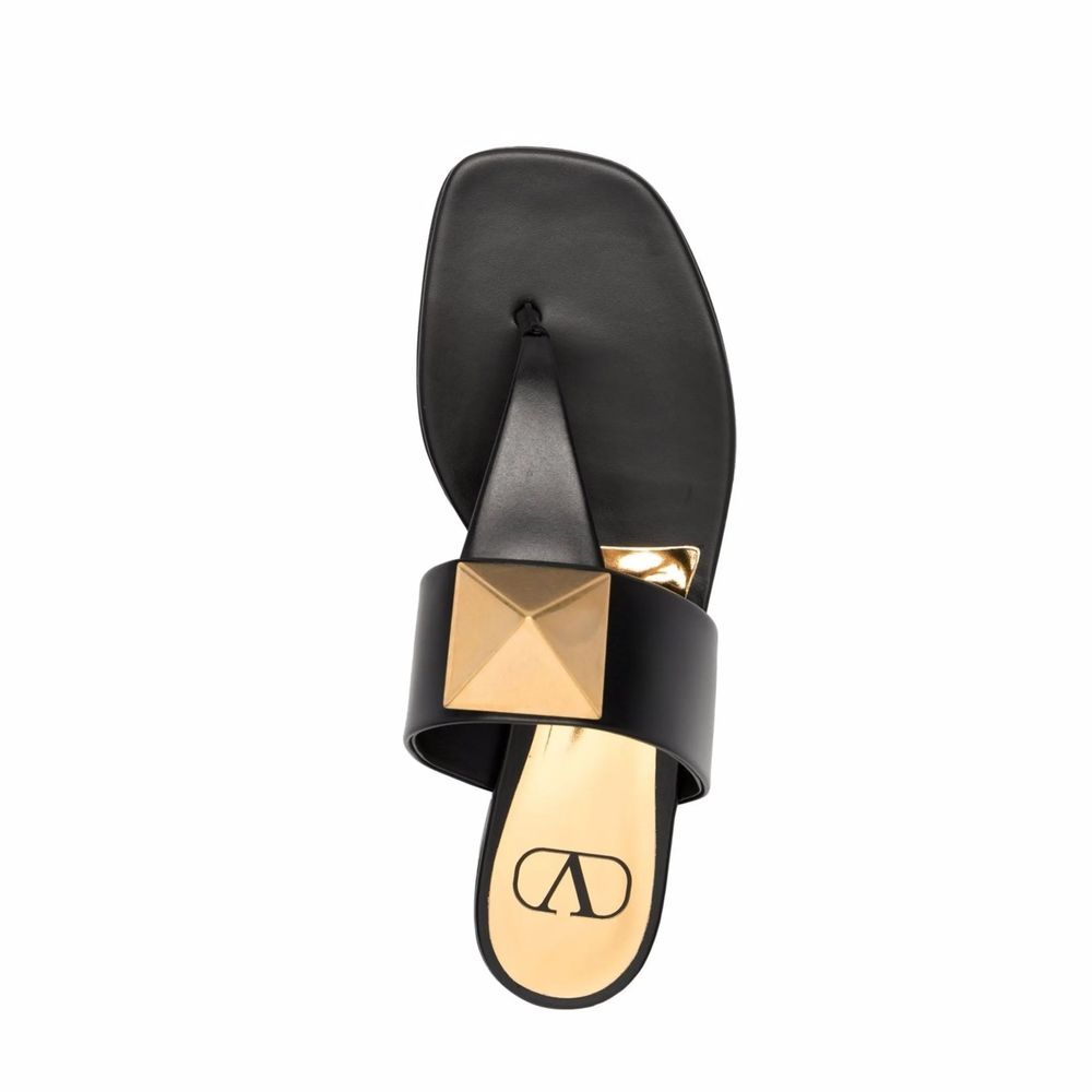 Valentino Garavani One Stud sandals in black leather with thong strap, round toe, and signature stud detail, viewed from above.