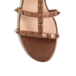 Alt Tag: Valentino Garavani Rockstud Low Slide Sandal in Laminated Nappa Leather, brown slip-on with signature Rockstud embellishment.