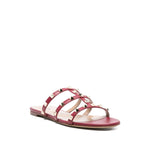 Valentino Garavani Rockstud three-strap sandals in red leather with flat sole and Rockstud embellishments, open toe design, heel 1 cm.