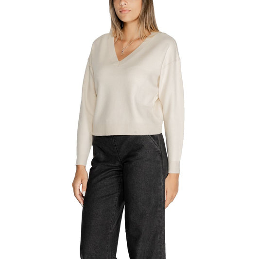 Woman wearing Vero Moda White Viscose Sweater with V-neck and long sleeves, styled with black trousers for a casual chic look.