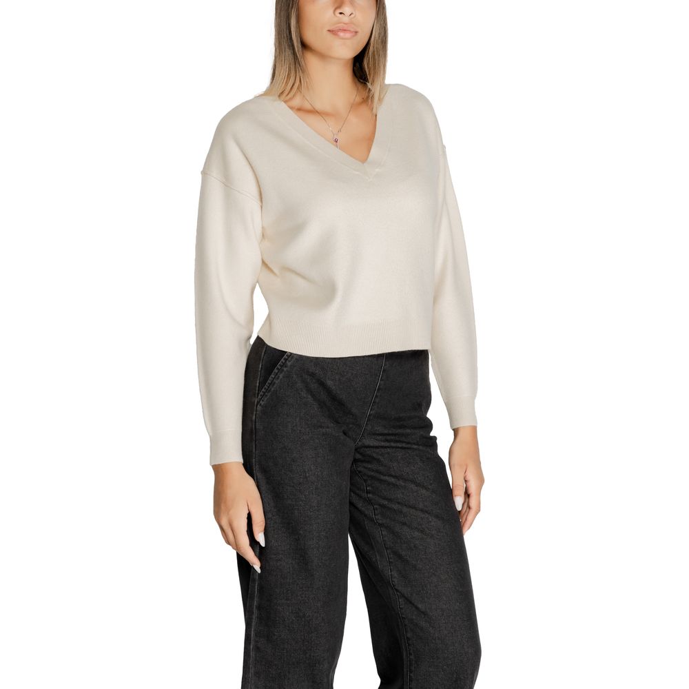 Woman wearing Vero Moda White Viscose Sweater with V-neckline and long sleeves, paired with black pants.