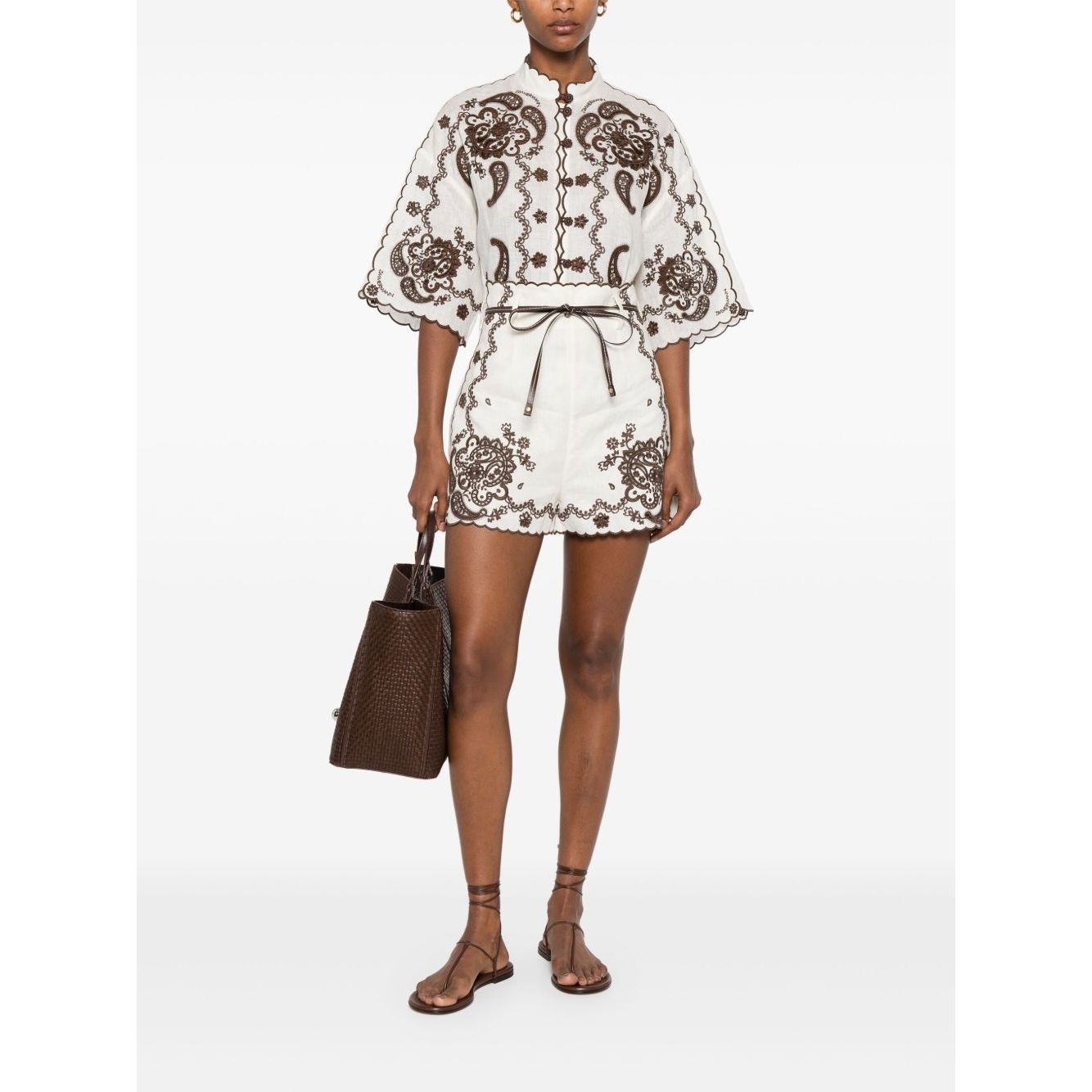 Model wearing Zimmermann Ascension Shorts with embroidered linen, scallop edge, concealed zip, belt loops, and detachable waist belt.